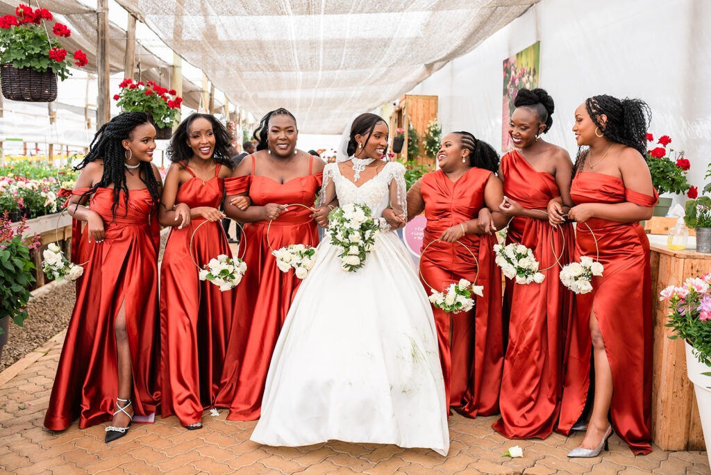 Kenyan wedding group photo: "Family and friends gathered for a group photo after the wedding ceremony, with a scenic Kenyan landscape in the background