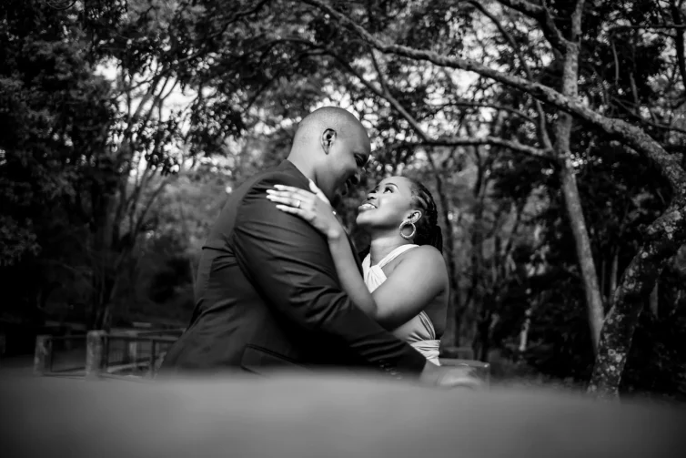 Romantic Kenyan wedding couple embracing in a lush outdoor setting.